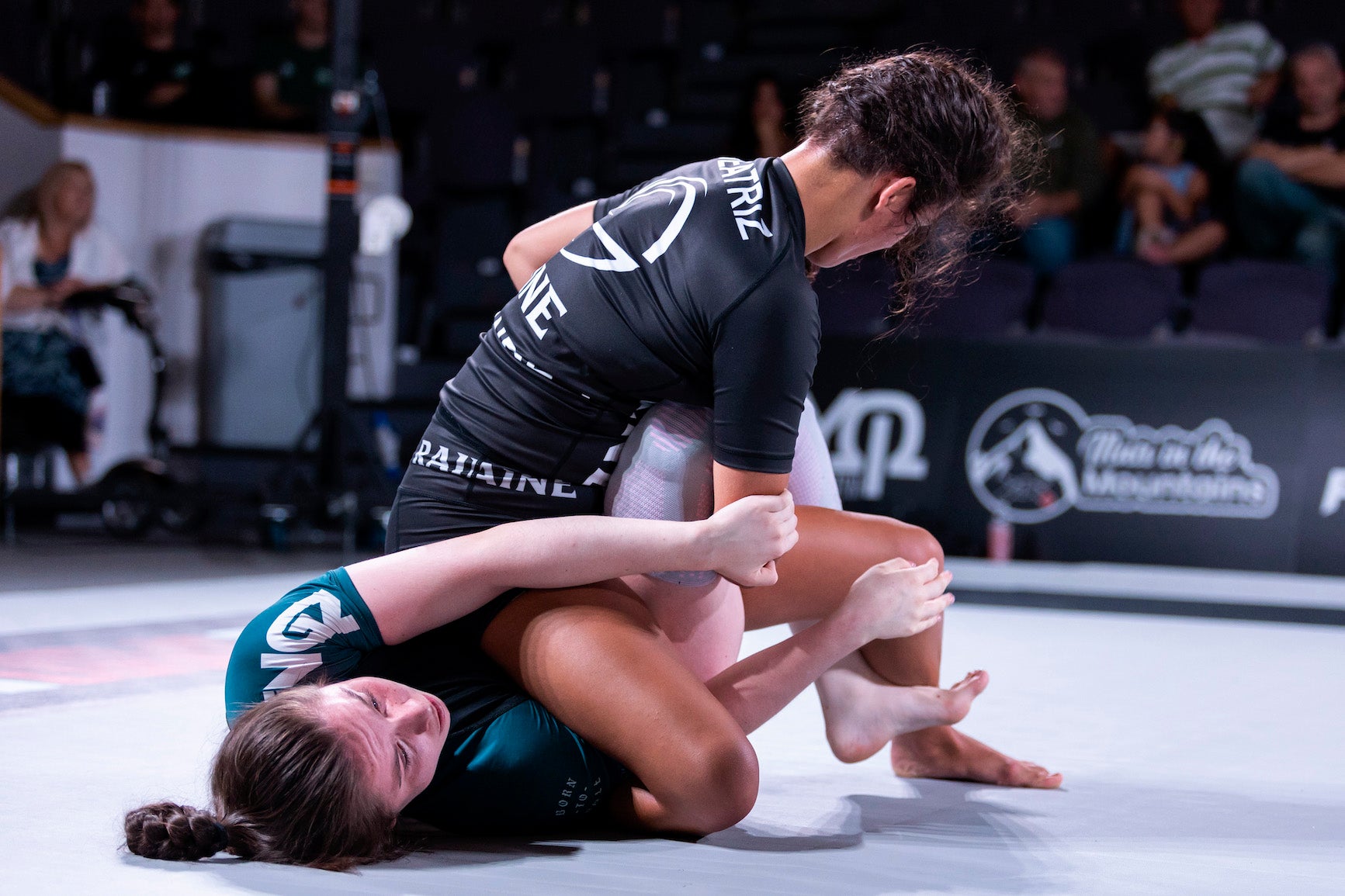 two women practicing jiu jitsu in competition