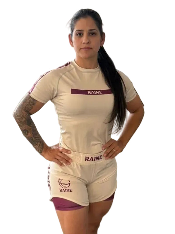 Woman wearing a beige nogi outfit with 'RAINE' branding on a white background