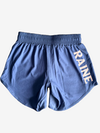 Blue shorts with 'RAINE' branding on a textured surface