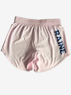 Pink shorts with Navy 'RAINE' branding textured gray surface