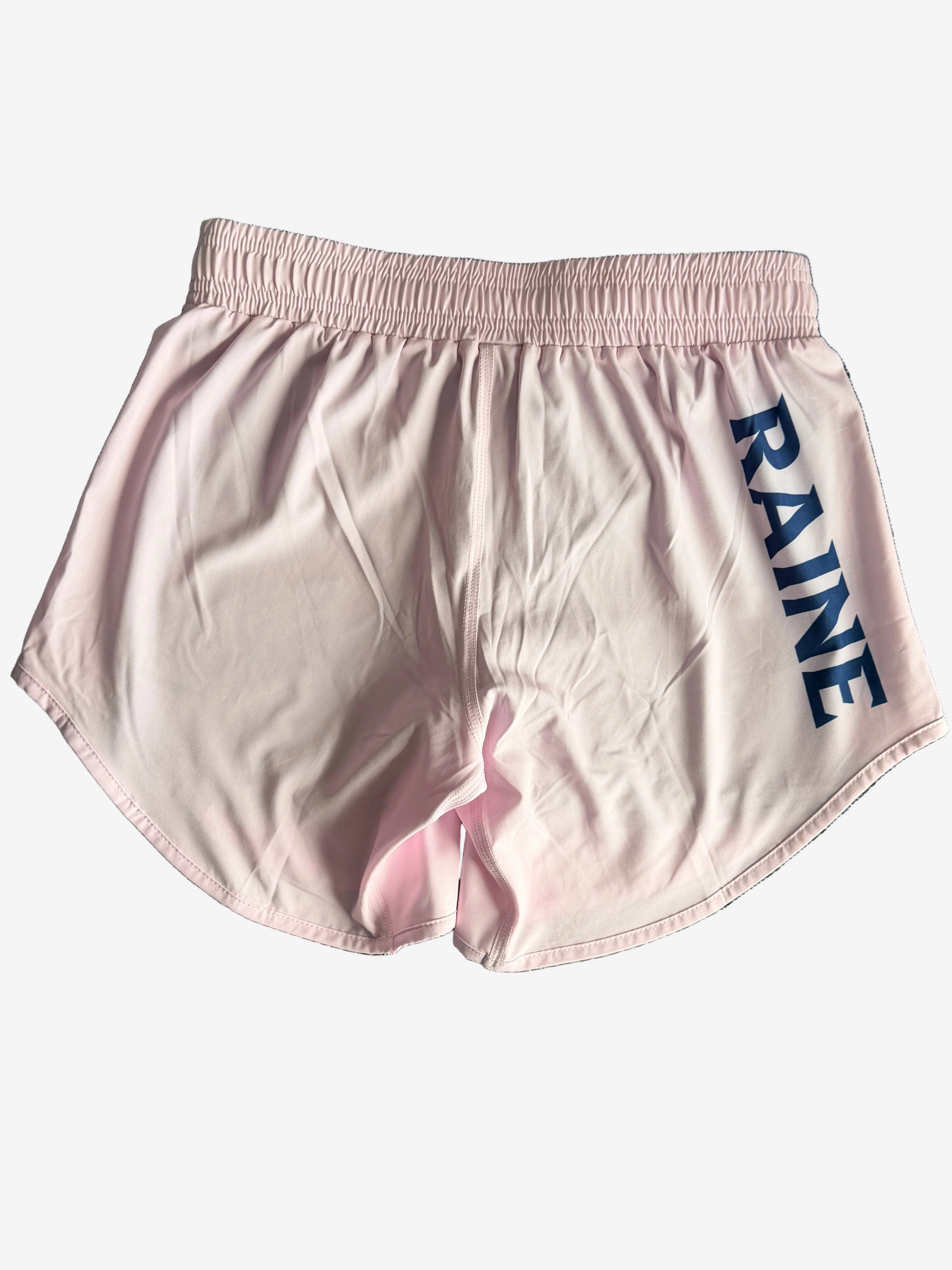 Pink shorts with Navy 'RAINE' branding textured gray surface